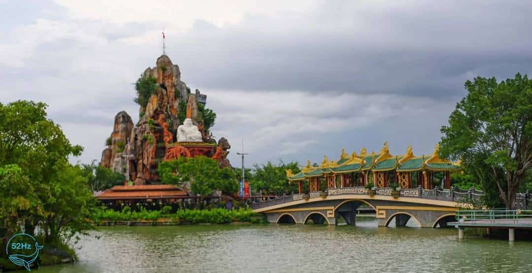 Toàn cảnh cây cầu, tượng đá và dòng sông tại khu du lịch Long Điền Sơn
